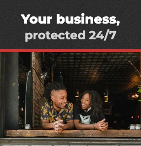 Shop owners at their shop window: your business, protected 24/7